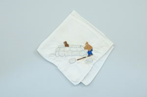 Image: Two figures building a snowhouse, one of a set of 4 embroidered napkins with scenes of Inuit ice life